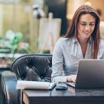 Young businesswoman with laptop and paperwork, with copy space.