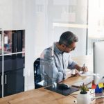 Cropped shot of a businessman working on his computer at his desk